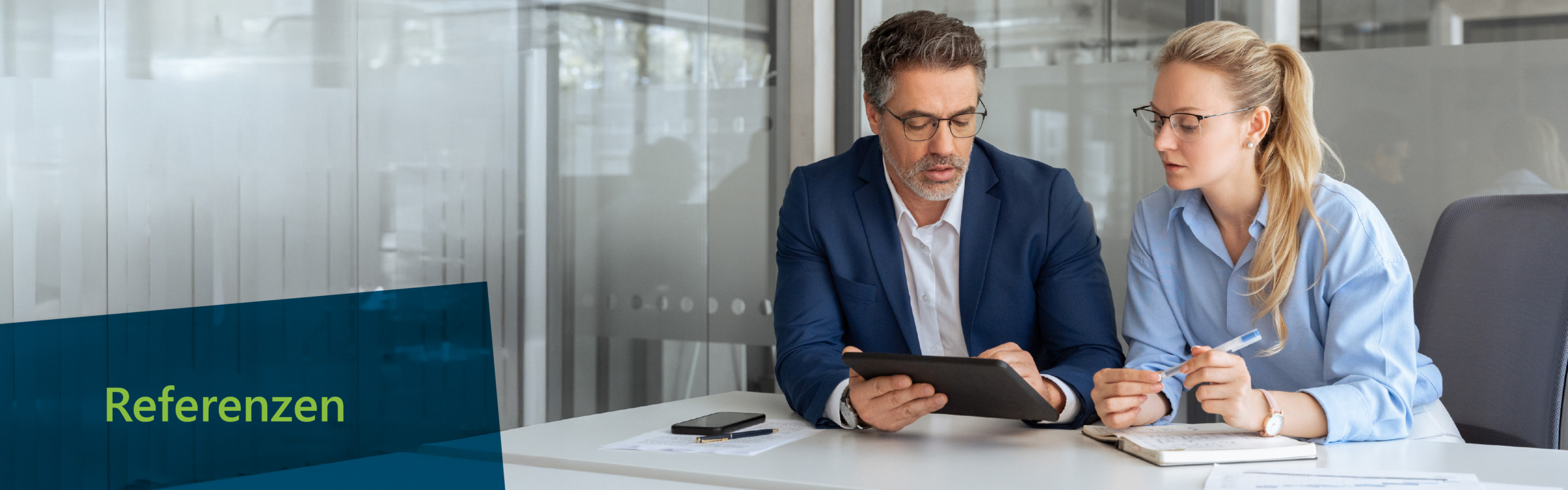 Zwei Fachleute sitzen an einem Schreibtisch in einer modernen Büroumgebung, überprüfen Informationen auf einem Tablet und machen sich Notizen. Eine blaue Überlagerung auf der linken Seite zeigt das Wort „Referenzen” in grüner Schrift. Von ITVT.